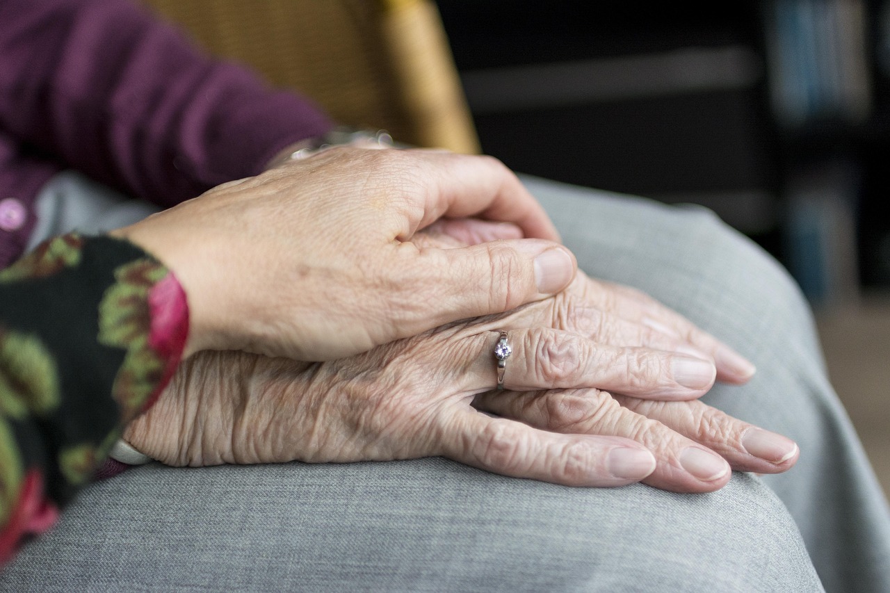 Caring hands supporting aging parent for ALTCS Medicaid planning